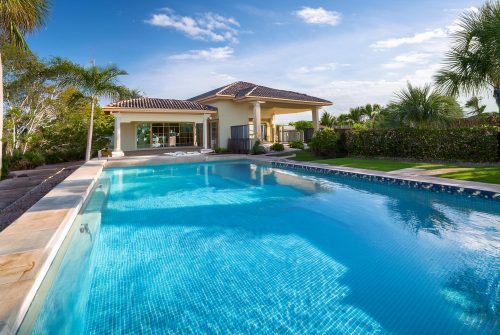 custom backyard luxury pool with a shed houses in the background