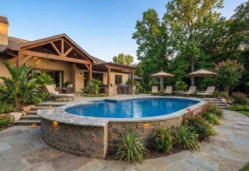 semi inground swimming pool with natural curves and stone patio design